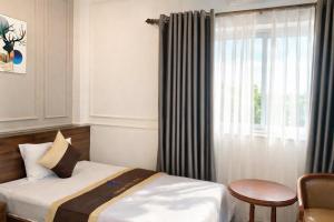 a hotel room with a bed and a window at Thuận Phát Hotel in Soc Trang +87 photos