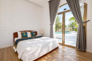 a bedroom with a bed and a sliding glass door at Thuận Phát Hotel in Soc Trang
