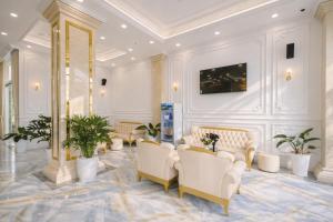 a waiting room with white chairs and plants at Thuận Phát Hotel in Soc Trang