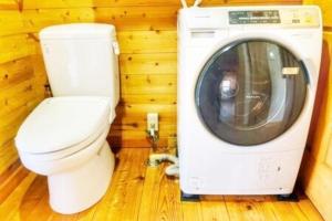 a small bathroom with a toilet and a washing machine at プールサイドヴィラ館山 in Tateyama