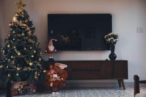 a christmas tree in a living room next to a tv at Homestay Mộc An in Lagi