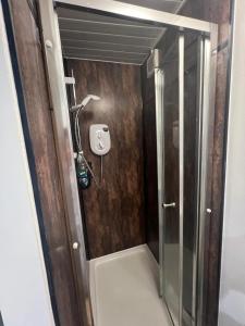 a shower with a glass door in a bathroom at Lovely Timber Lodge Ensuite room in Corby Town centre NN17 in Rockingham