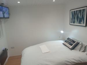 a white bed in a room with a tv at Lovely Timber Lodge Ensuite room in Corby Town centre NN17 in Rockingham