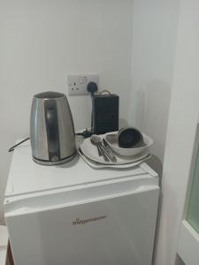 a microwave and a toaster sitting on top of a refrigerator at Lovely Timber Lodge Ensuite room in Corby Town centre NN17 in Rockingham