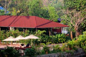 a group of tables with umbrellas in front of a building at Ayurprana Marari in Mararikulam