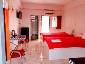a bedroom with two beds and a table and chairs at ลพบุรีทาวน์ Lopburi Town in Lop Buri