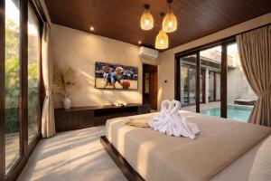 a bedroom with a bed and a large window at Eden Villas Lombok in Kuta Lombok