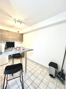 a kitchen with a table and chairs in a room at Studio Cosy proche CHU in Amiens +4 photos