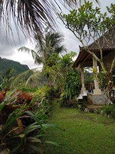 a house with a green yard with a tree at The Bukit Artha in Sidemen