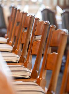 a row of wooden chairs sitting in a row at Hotel & Restaurant Ernst in Giesen