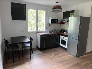 a kitchen with a table and a refrigerator at Cottage near Clisson in Gétigné