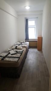 um quarto com 2 camas num quarto com uma janela em Apartmán u červeného kostela em Teplice