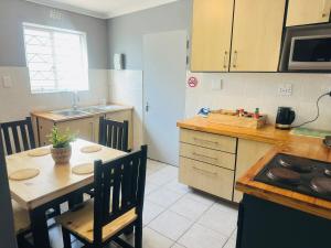 a kitchen with a table and chairs and a kitchen with a stove at AAA Luxury Cottages in Cape Town +11 photos