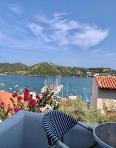 a chair sitting on a balcony with a view of a harbor at Oikies Skiathos in Skiathos