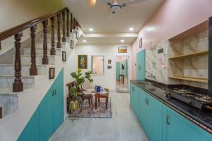 a kitchen with turquoise cabinets and a staircase at Shri Prem Villa in Jaisalmer