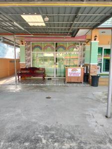 an empty parking lot with a bench in front of a building at บ้านพัก สายรุ้ง in Ban Hua Saphan +1 photo