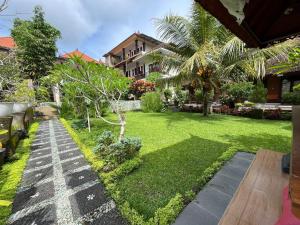 a garden with a lawn and a house at Puji Bisma Ubud in Ubud