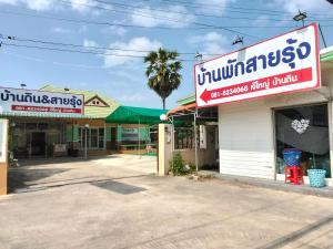 a store with a sign on the side of a street at บ้านพัก สายรุ้ง in Ban Hua Saphan