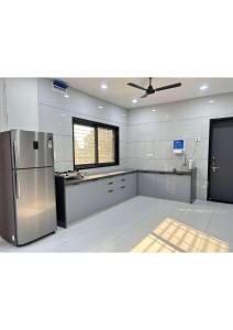 a kitchen with a stainless steel refrigerator and a window at Grey Stone Farm House in Surat