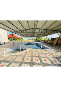 a swimming pool in a parking lot under a building at Grey Stone Farm House in Surat