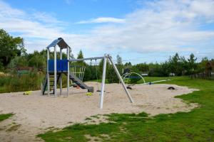 a playground with a swing set in the sand at Campland in Arcen
