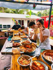 a group of people sitting at a table with food at Mitra Palolem in Palolem