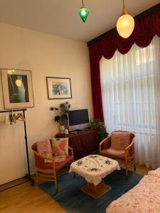 a living room with a table and chairs and a tv at Villa Pazelt Top1 in Bad Vöslau