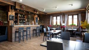 a bar in a restaurant with tables and chairs at Alpejski Zieleniec in Duszniki Zdrój