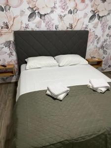 a bedroom with a bed with two towels on it at Vila Seawolf Apartments in Sutomore