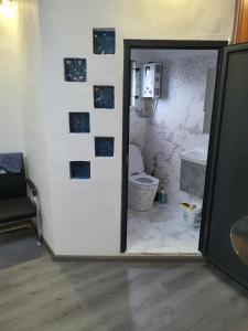 a bathroom with a toilet and a wall with tiles at Jannat Residence in Curepipe