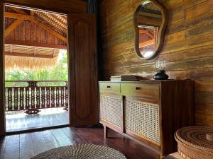 a room with a wooden wall with a mirror and a dresser at Secret Beach Beachfront Villa in Papak