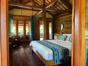 a bedroom with a bed in a wooden room at Secret Beach Beachfront Villa in Papak