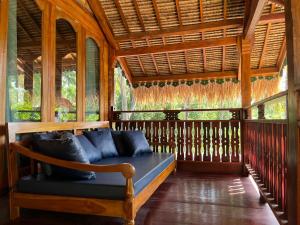 a porch with a couch in a room with windows at Secret Beach Beachfront Villa in Papak +44 photos