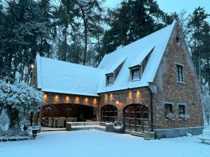a brick building with a snow covered roof at oh deer in Aalter
