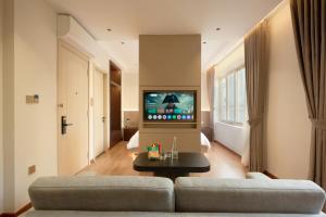 a living room with a couch and a tv at HAITA Suites - Phu My Hung in Ho Chi Minh City