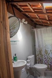 a bathroom with a sink and a toilet and a mirror at Casa Petar Betari in Iporanga