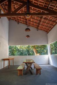 a picnic table and benches in a room with trees at Casa Petar Betari in Iporanga +95 photos