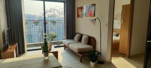 a living room with a couch and a large window at SHome, căn hộ 55m2,2 phòng ngủ, Oceanpark 1 in Gia Lâm Pho +13 photos