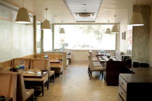 a restaurant with tables and chairs and a large window at Varju Villa in Udaipur