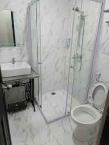a bathroom with a shower and a toilet and a sink at Homestay Harmonie Cepu in Padangan +7 photos
