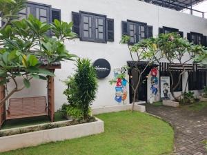 a white building with black windows and plants at Homestay Harmonie Cepu in Padangan