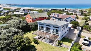 an aerial view of a house and the ocean at Sunny Beach House in Cape St Francis