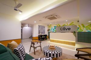 a living room with a couch and a table at Olive Hotel Wakad by Embassy Group in Pune