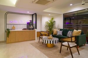 a living room with a couch and a table at Olive Hotel Wakad by Embassy Group in Pune