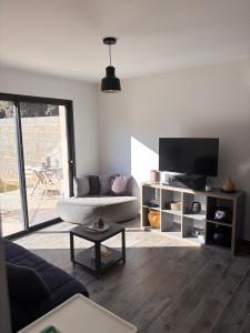 a living room with a couch and a tv at Gîte du Courbier in Saint-Montan