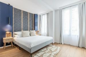 a bedroom with a bed and a blue wall at Le Bastille By Sweett in Paris +17 photos
