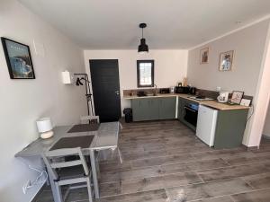 a kitchen with a desk and a table and a table and chairs at Gîte du Courbier in Saint-Montan +4 photos