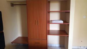 a closet with wooden shelves and a wooden cabinet at palm ridge apartment Diani beach in Diani Beach