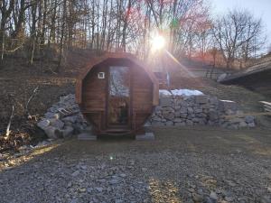 a small wooden cabin with the sun in the background at Čarovná chatka in Vyhne
