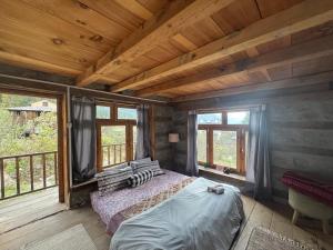 a bedroom with a bed in a room with windows at Enter The Wild in Kalgha
